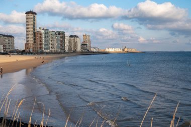 Rıhtım, kum tepeleri ve Vlissingen şehri, güneşli günbatımında kumlu plaj, Zeeland, Hollanda