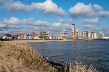 Rıhtım, kum tepeleri ve Vlissingen şehri, güneşli günbatımında kumlu plaj, Zeeland, Hollanda