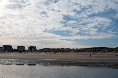 Küçük Belçika kasabası De Haan veya Le Coq sur mer 'deki sarı kumlu sahilde alçak uçuş süresi, lüks tatil beldesi, güneşli bir günde yaz tatili