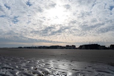 Küçük Belçika kasabası De Haan veya Le Coq sur mer 'deki sarı kumlu sahilde alçak uçuş süresi, lüks tatil beldesi, güneşli bir günde yaz tatili
