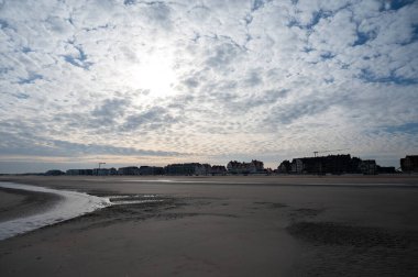 Küçük Belçika kasabası De Haan veya Le Coq sur mer 'deki sarı kumlu sahilde alçak uçuş süresi, lüks tatil beldesi, güneşli bir günde yaz tatili