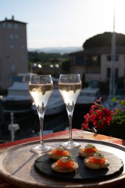 Rus tarzı parti, iki bardak soğuk şampanya, kırmızı havyarlı bulanık ve Saint-Tropez yakınlarındaki Port Grimaud manzaralı, yazın Fransız Riviera 'sında tatiller.