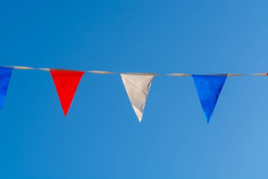 Hollanda bayrağının renkleriyle renkli çelenkler, güneşli mavi gökyüzünde beyaz, kırmızı ve mavi