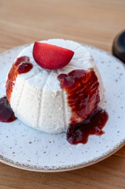 Peynir koleksiyonu, beyaz İtalyan yumuşak peyniri ricotta ev yapımı erik reçeli ve taze olgun erikli tatlı olarak servis edilir.