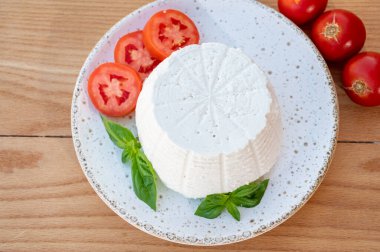 Peynir koleksiyonu, taze domates ve fesleğenle servis edilen yumuşak İtalyan organik peyniri ricotta.