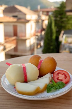 Peynir koleksiyonu, çeşitli İtalyan inek sütü peyniri scamorza İtalyan evleri güneşli bir günde arka planda