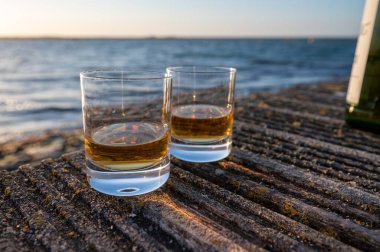 Gün batımında İskoç viskisi içmek deniz, okyanus veya nehir manzaralı, İskoçya, İngiltere 'de özel viski imalathanesi turları