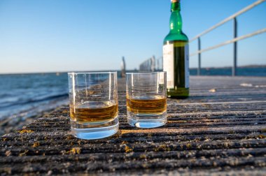 Gün batımında İskoç viskisi içmek deniz, okyanus veya nehir manzaralı, İskoçya, İngiltere 'de özel viski imalathanesi turları