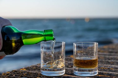 Gün batımında İskoç viskisi içmek deniz, okyanus veya nehir manzaralı, İskoçya, İngiltere 'de özel viski imalathanesi turları