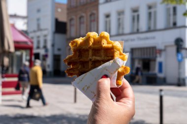 Taze pişmiş Belçika şekerli waffle 'lar, Bruges' de sokak yemekleri yemek.