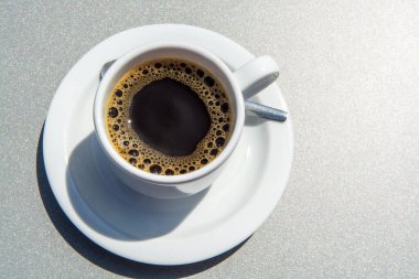 Beyaz kahve fincanı gri arka planda, yakın plan.