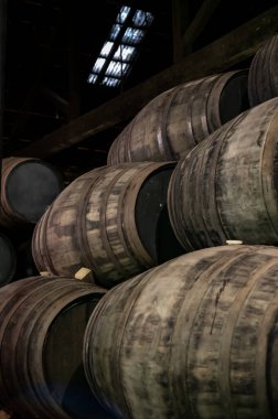 Portekiz 'in kuzeyindeki Vila Nova de Gaia' da güçlendirilmiş yakut ya da tawny porto şarabının yavaş yaşlanması için meşe ağacı fıçılarıyla dolu eski bir porto kulübesi.