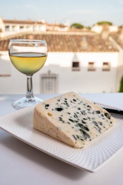 Peynir koleksiyonu, Roquefort-sur-Soulzon, Fransa 'dan yarı sert Fransız rokfor peyniri, soğuk beyaz Fransız şarabı ile servis edilir, yakın çekim.