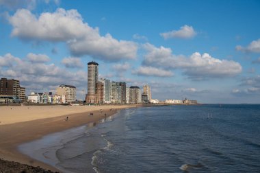 Rıhtım, kum tepeleri ve Vlissingen şehri, güneşli günbatımında kumlu plaj, Zeeland, Hollanda