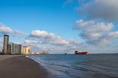 Rıhtım, kum tepeleri ve Vlissingen şehri, güneşli günbatımında kumlu plaj, Zeeland, Hollanda