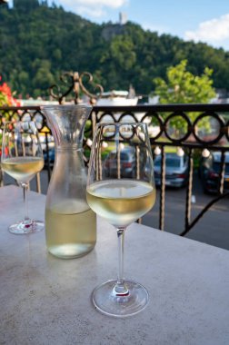 Beyaz kaliteli şarap tatma Mosel şarap bölgesinde açık terasta servis edilir ve güneşli bir günde arka planda eski Alman kasabası, Almanya