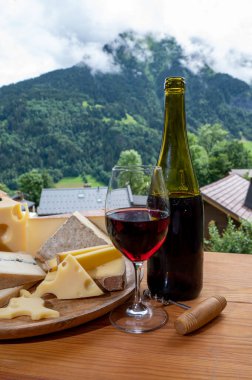 Peynir koleksiyonu, Fransız peynirli ahşap pano kont, Beaufort, abondance, emmental, morbier, Savoie 'den kırmızı şarap ve yazın Haute-Savoie' deki Fransız dağları köyünden gelen kırmızı şarap.