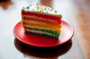 Bir parça taze fırınlanmış renkli doğum günü pastası.