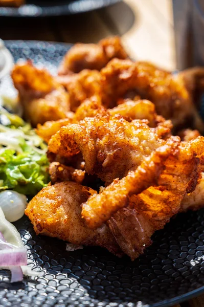 Dutch street food, fried pieces of cod fish fillet served with garlic sauce and fresh green salade close up