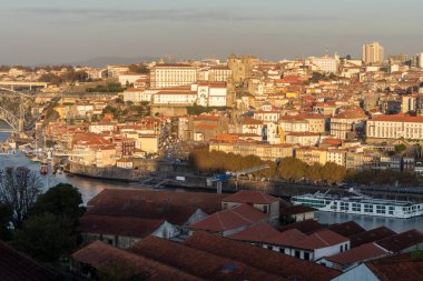 Porto ve Vila Nova de Gaia, 29 Ekim 2020, güneşli bir günde Portekiz 'in Porto şehrinin eski bir bölgesinde panoramik manzara ve şarap mahzenlerinin şarap stoklandığı ve yaşlandığı kırmızı çatılar