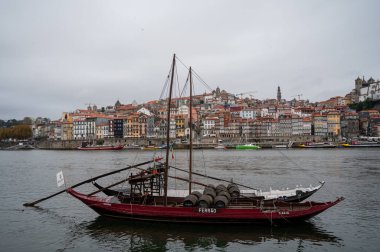 Porto, Portekiz, 31 Ekim 2020. Vila Nova de Gaia 'dan liman imalatçılarının botları ve şehrin eski kesimindeki renkli eski evlerin manzarası. Douro nehrinin seti.
