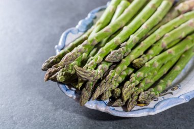 Taze yeşil kuşkonmaz sebzeleri yakın pişmeye hazır.