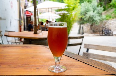 Bira fabrikasından siyah bal birası, açık havada ahşap masada servis edilir.