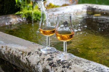 Bir bardak sert viski, viski, İskoçya 'daki dağ pınarından gelen su için eski taş rezervlerinde servis edilir.