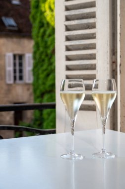 Romantik bir parti, iki bardak soğuk şampanya köpüklü köpüklü köpüklü şarap ve Fransız köyündeki eski cadde manzaralı.