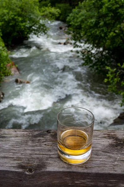 Bir Bardak Sert Viski Arka Planda Hızlı Akan Dağ Nehri — Stok fotoğraf