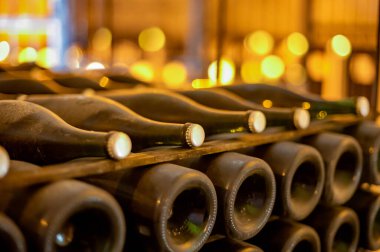 Derin ve uzun yeraltı mağaralarında, raflarda tozlu şişelerle yürür, Chardonnay 'den şampanya ve Reims, Champagne, France' da pinor noir üzümleri yapar.