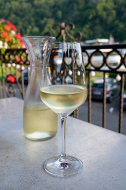 Beyaz kaliteli şarap tatma Mosel şarap bölgesinde açık terasta servis edilir ve güneşli bir günde arka planda eski Alman kasabası, Almanya