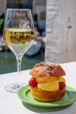 Tarte tropezienne ya da La Tarte de Saint-Tropez. Açık havada servis edilen kremalı ve taze meyveli çöreklerden oluşan tatlı tatlısı. Bir kadeh beyaz şarapla.