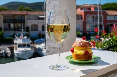 Tarte tropezienne ya da La Tarte de Saint-Tropez. Açık havada servis edilen kremalı ve taze meyveli çöreklerden oluşan tatlı tatlısı. Bir kadeh beyaz şarapla.