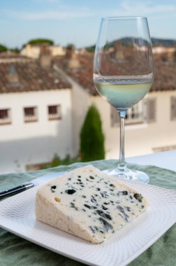 Peynir koleksiyonu, Roquefort-sur-Soulzon, Fransa 'dan yarı sert Fransız rokfor peyniri, soğuk beyaz Fransız şarabı ile servis edilir, yakın çekim.