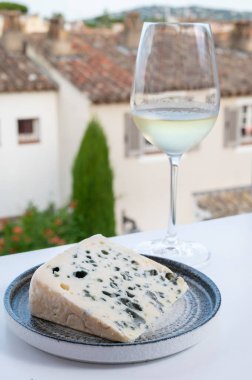 Peynir koleksiyonu, Roquefort-sur-Soulzon, Fransa 'dan yarı sert Fransız rokfor peyniri, soğuk beyaz Fransız şarabı ile servis edilir, yakın çekim.