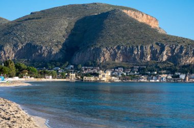 Deniz kenarında güneşli bir gün, Mondello Sahili, Sicilya 'da Palermo yakınlarında, güzel, altın kumu, turkuaz suları ve İtalya' nın güneyinde büyüleyici villaları olan.