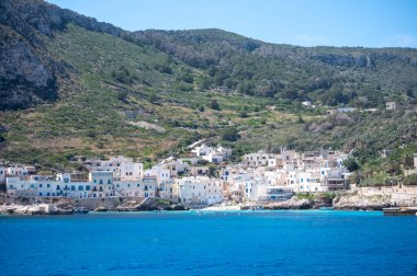 Levanzo, Egadi Adaları 'nın en küçüğü, Sicilya yakınlarında sakin bir inziva yeri, liman çevresindeki pitoresk köy, beyaz evler ve büyüleyici açık mavi su limanı, seyahat yeri, tekne gezisi.