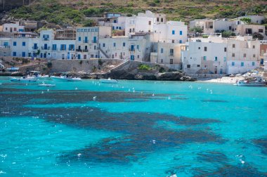 Levanzo, Egadi Adaları 'nın en küçüğü, Sicilya yakınlarında sakin bir inziva yeri, liman çevresindeki pitoresk köy, beyaz evler ve büyüleyici açık mavi su limanı, seyahat yeri, tekne gezisi.