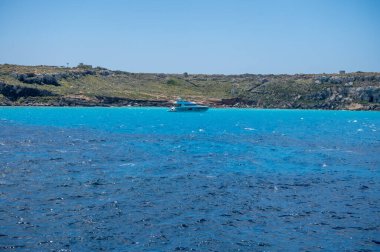 Trapani 'den tekne gezisi ve açık turkuvaz suyu, tuff kayaları, terk edilmiş taş ocakları, Sicilya, İtalya yakınlarındaki Egadi Adaları ile birlikte Favignana adasının kıyı şeridi manzarası.