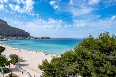 Deniz kenarında güneşli bir gün, Mondello Sahili, Sicilya 'da Palermo yakınlarında, güzel, altın kumu, turkuaz suları ve İtalya' nın güneyinde büyüleyici villaları olan.