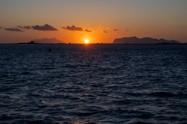 Marsala Stagnone sularında gün batımı, Marsala, Sicilya, İtalya yakınlarındaki tuzlu lagün ve doğa rezervi, sığ, ılık su, tuz tavaları, antik yel değirmenleri ile eşsiz ekosistem