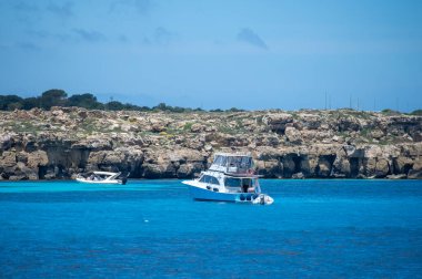Trapani 'den tekne gezisi ve açık turkuvaz suyu, tuff kayaları, terk edilmiş taş ocakları, Sicilya, İtalya yakınlarındaki Egadi Adaları ile birlikte Favignana adasının kıyı şeridi manzarası.