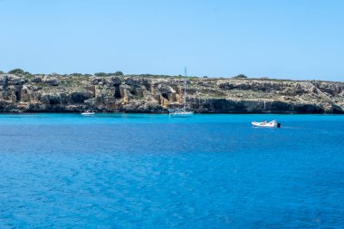 Trapani 'den tekne gezisi ve açık turkuvaz suyu, tuff kayaları, terk edilmiş taş ocakları, Sicilya, İtalya yakınlarındaki Egadi Adaları ile birlikte Favignana adasının kıyı şeridi manzarası.