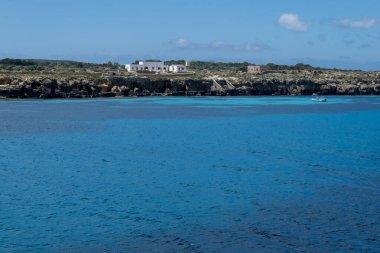 Trapani 'den tekne gezisi ve açık turkuvaz suyu, tuff kayaları, terk edilmiş taş ocakları, Sicilya, İtalya yakınlarındaki Egadi Adaları ile birlikte Favignana adasının kıyı şeridi manzarası.