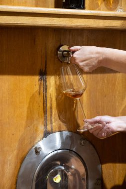 Eski büyük meşe fıçılarıyla şarap mahzenini ziyaret etmek, Marsala, Sicilya, İtalya ve şarap endüstrisindeki fıçılardan güçlendirilmiş veya tatlı marsala şarabı dökmek.