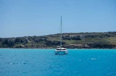 Trapani 'den tekne gezisi ve açık turkuvaz suyu, tuff kayaları, terk edilmiş taş ocakları, Sicilya, İtalya yakınlarındaki Egadi Adaları ile birlikte Favignana adasının kıyı şeridi manzarası.