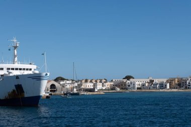 Trapani 'den tekne gezisi ve açık turkuvaz suyu, küçük bir köy, terk edilmiş taş ocakları, Sicilya, İtalya yakınlarındaki Egadi Adaları ile Favignana adasının kıyı şeridi manzarası.