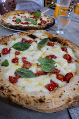 İtalyan pizzacıda fırın fırını, fırın, pizza ve pizza yemek. Kapatın.