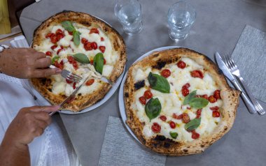 İtalyan pizzacıda fırın fırını, fırın, pizza ve pizza yemek. Kapatın.